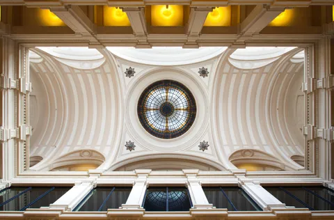 Foto da parte interna da estação das artes. O lustre está aceso e a foto é alaranjada.